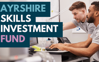 Image showing one employee training another with overlay text "Ayrshire Skills Investment Fund"
