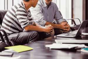 Two people sat in front of laptop
