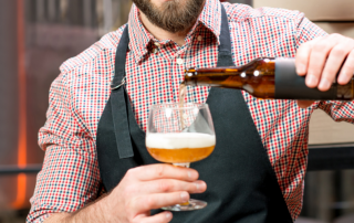Person pouring drink from a bottle