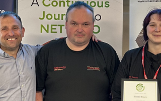 Three people standing with a certificate