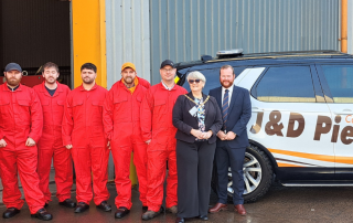 People standing in line in front of industrial space and J&D Pierce branded vehicle