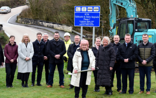 Group of people in front of construction vehicle and road