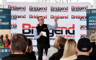 Person presenting to audience in front of crowd